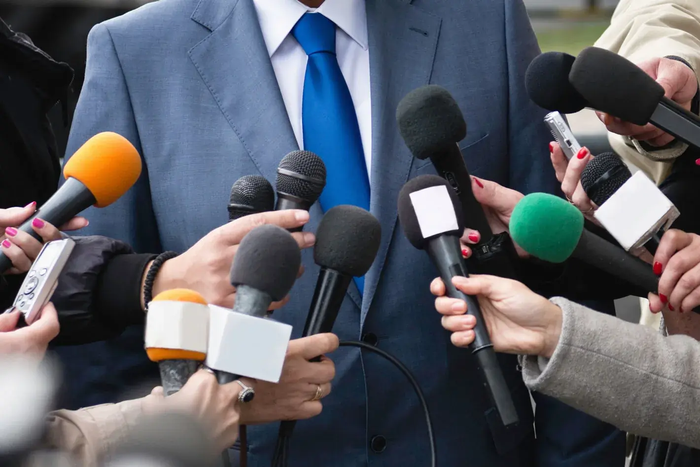 Journalist with microphone and camera crew covering the event